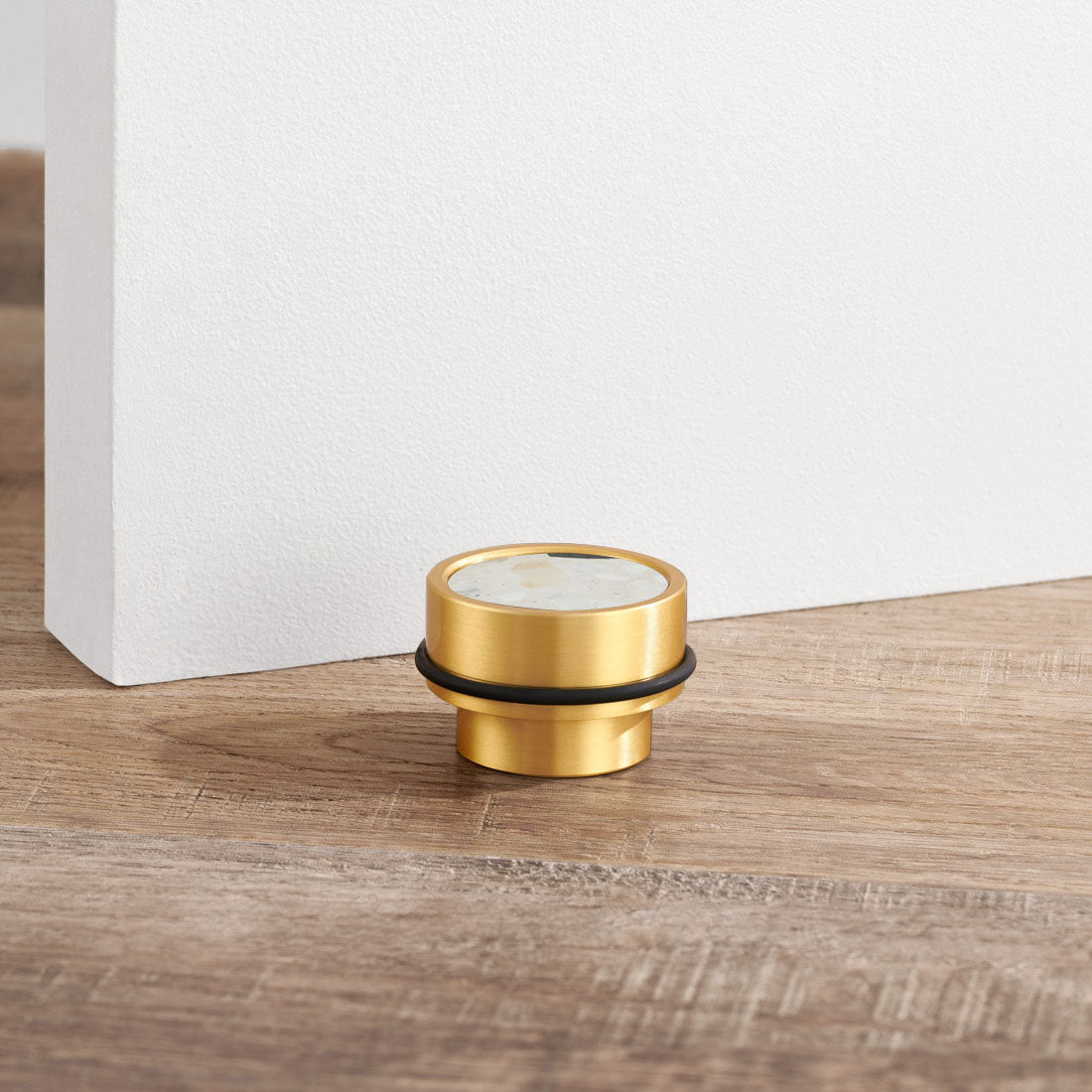 Brass & White Fleck Terrazzo Floor Mounted Door Stops in Gold